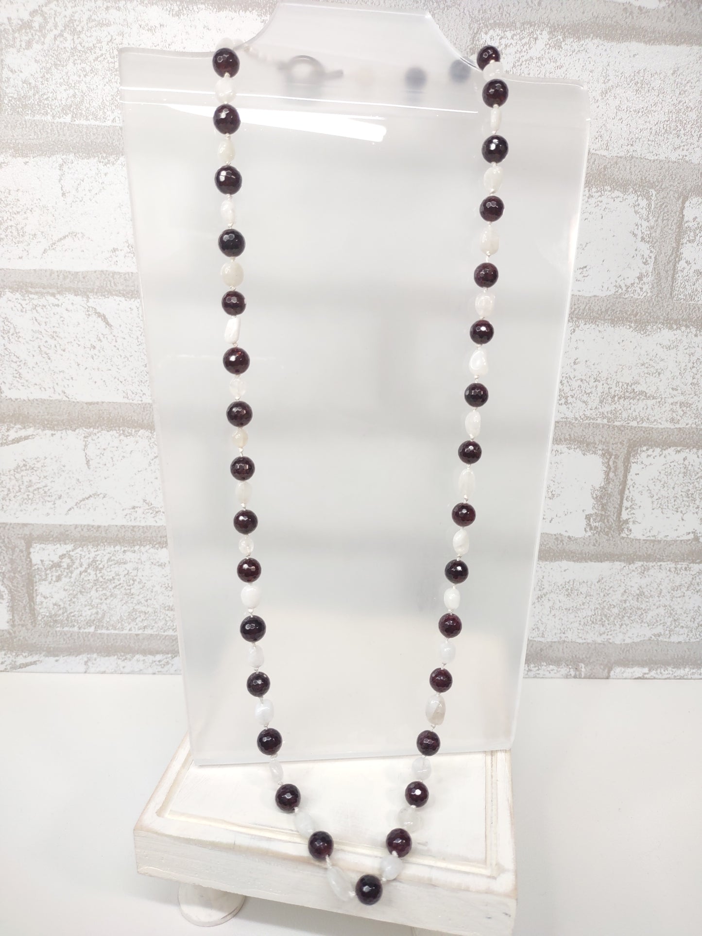 Large Faceted Garnet Beads and Moonstone nugget beads strung on 100% silk cord hand-knotted to separate each bead and finished with a stainless steel toggle.