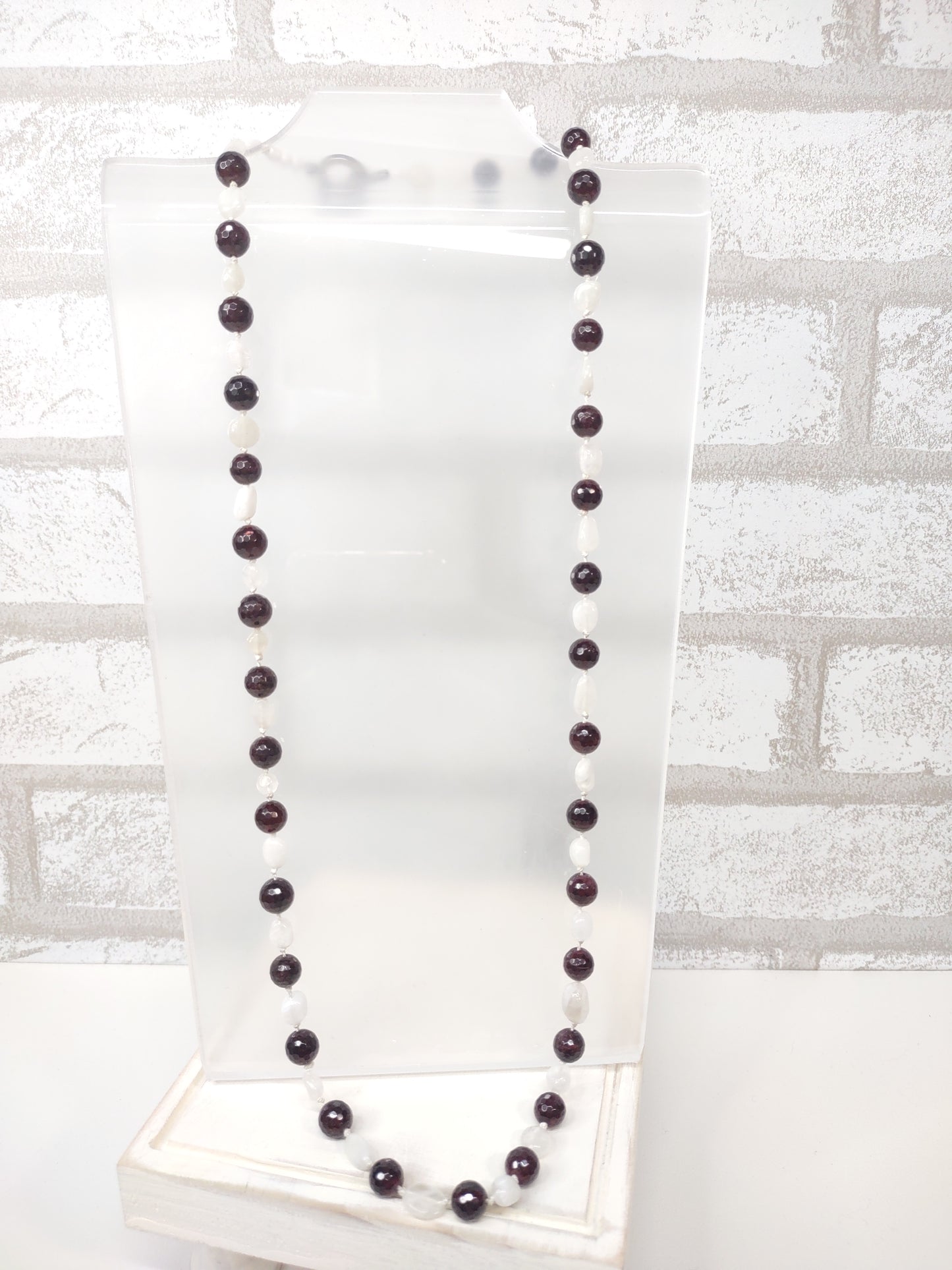 Large Faceted Garnet Beads and Moonstone nugget beads strung on 100% silk cord hand-knotted to separate each bead and finished with a stainless steel toggle.