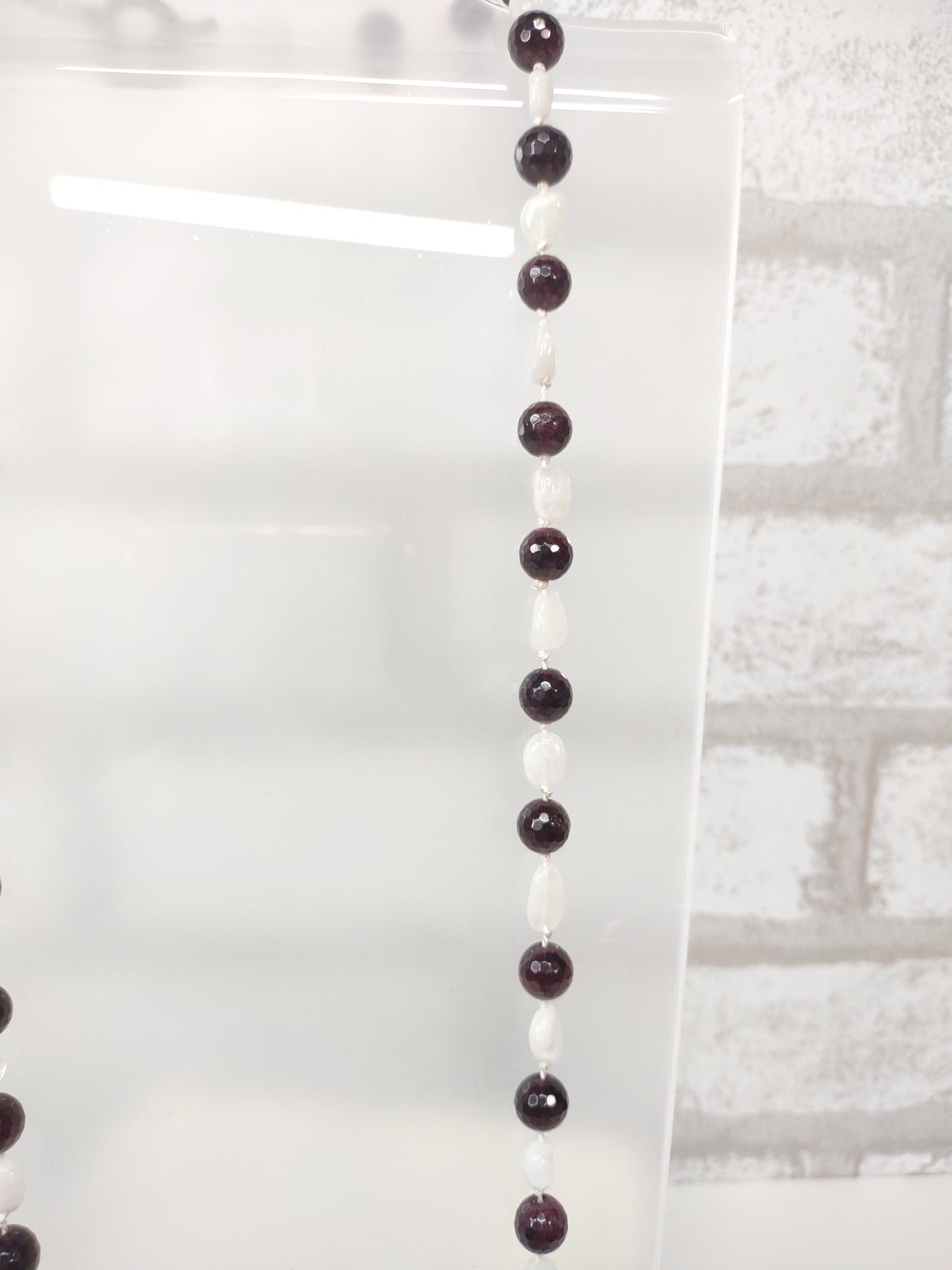 Large Faceted Garnet Beads and Moonstone nugget beads strung on 100% silk cord hand-knotted to separate each bead and finished with a stainless steel toggle.