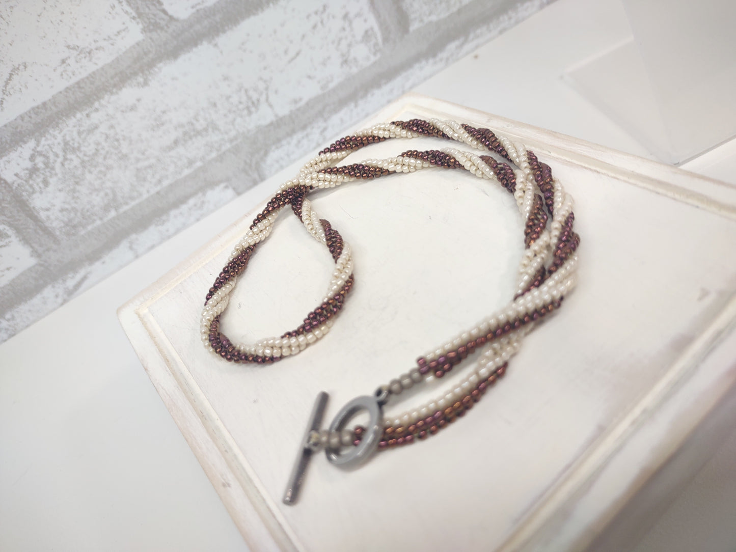 ivory and twisted beaded herringbone necklace with stainless steel toggle clasp - laying down rather than on display